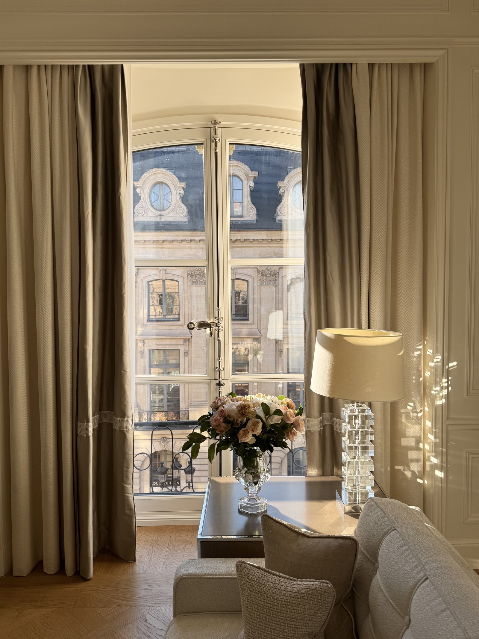 Fresh flowers on a desk beside a tall window